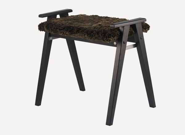 Svart träpall med brun fårskinnssits och handtag, skandinavisk design