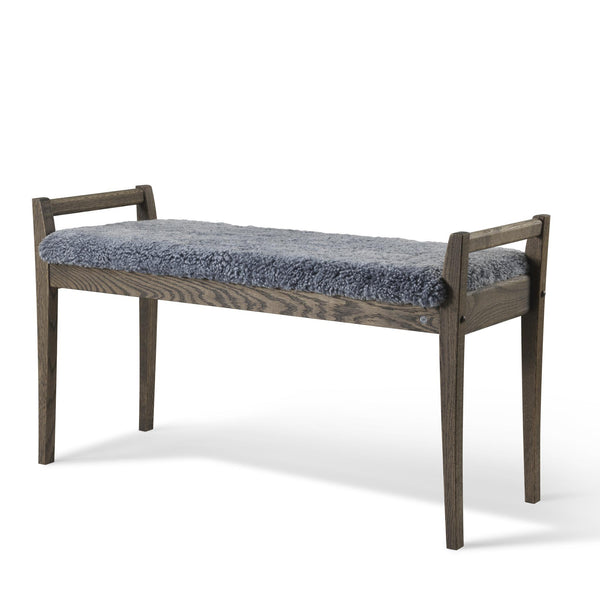 Bänk med grå fårskinnsdyna och mörkbrunt trästativ med ryggstöd