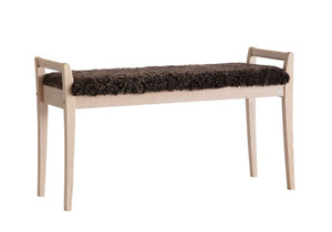 Bänk i ljust trä med mörk luddig pälsimitation som sits, skandinavisk design med smala ben