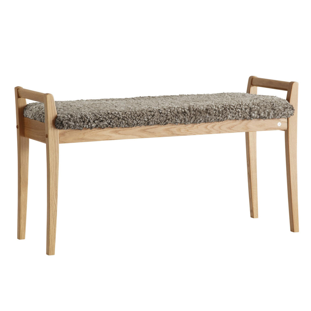 Bänk i ekträ med grå ullig fårskinnsdyna, skandinavisk design med smala ben och armstöd