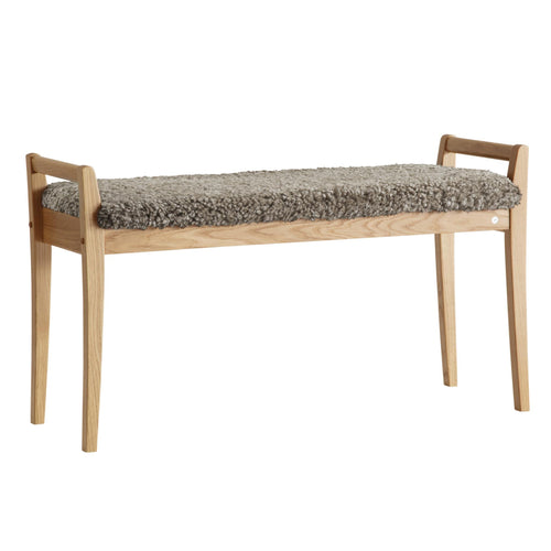 Bänk i ekträ med grå ullig fårskinnsdyna, skandinavisk design med smala ben och armstöd