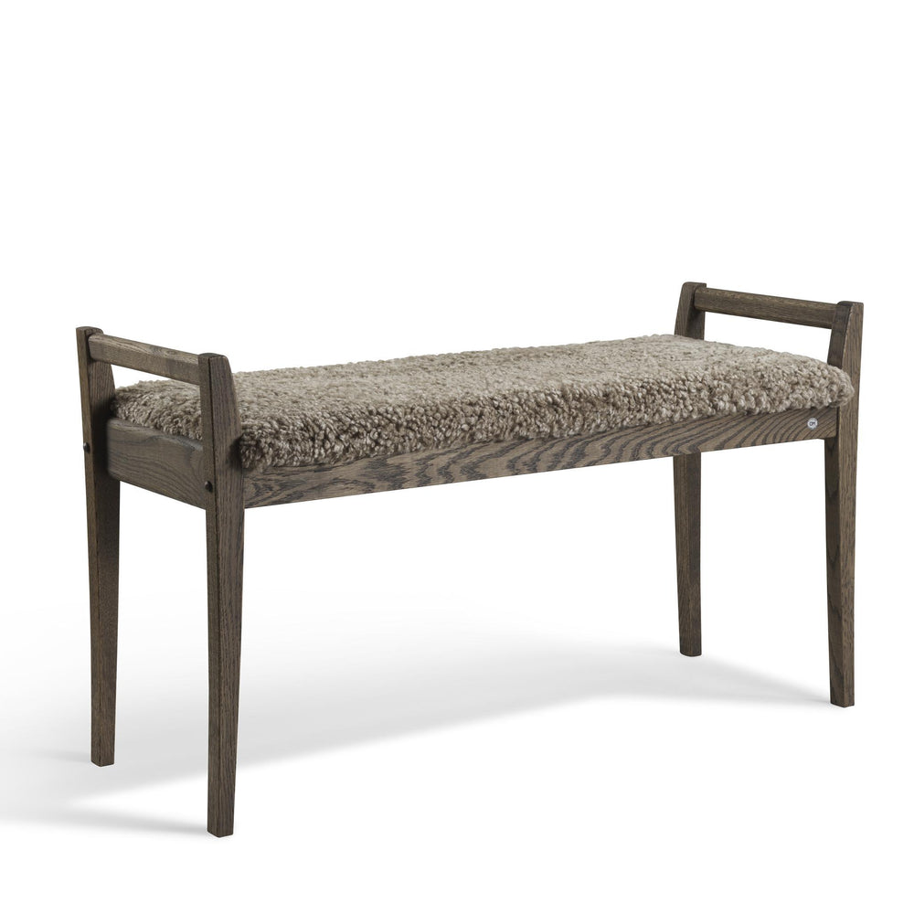 Bänk i ekträ med grå ullig fårskinnsdyna, skandinavisk design med smala ben och armstöd