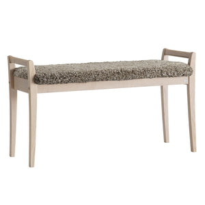 Bänk med ljust trästomme och grå sittdyna i fårskinn, skandinavisk design