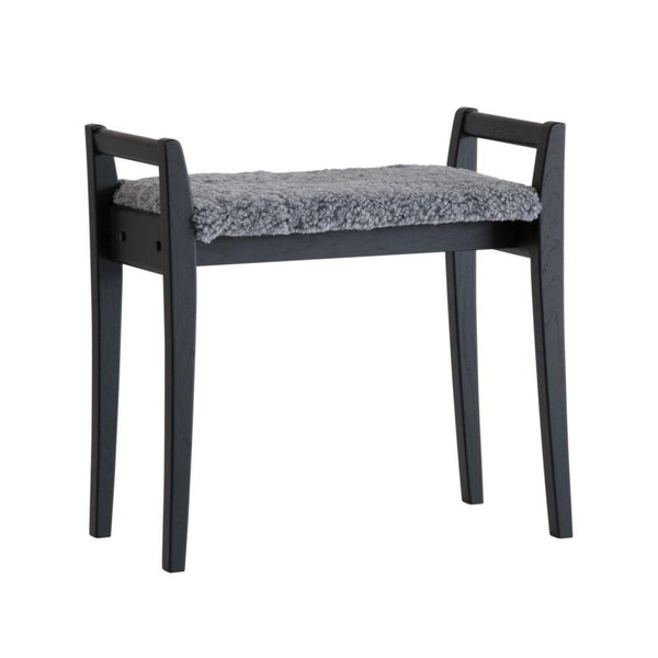 Grå pall med svarta träben och fluffig sittdyna i fuskpäls