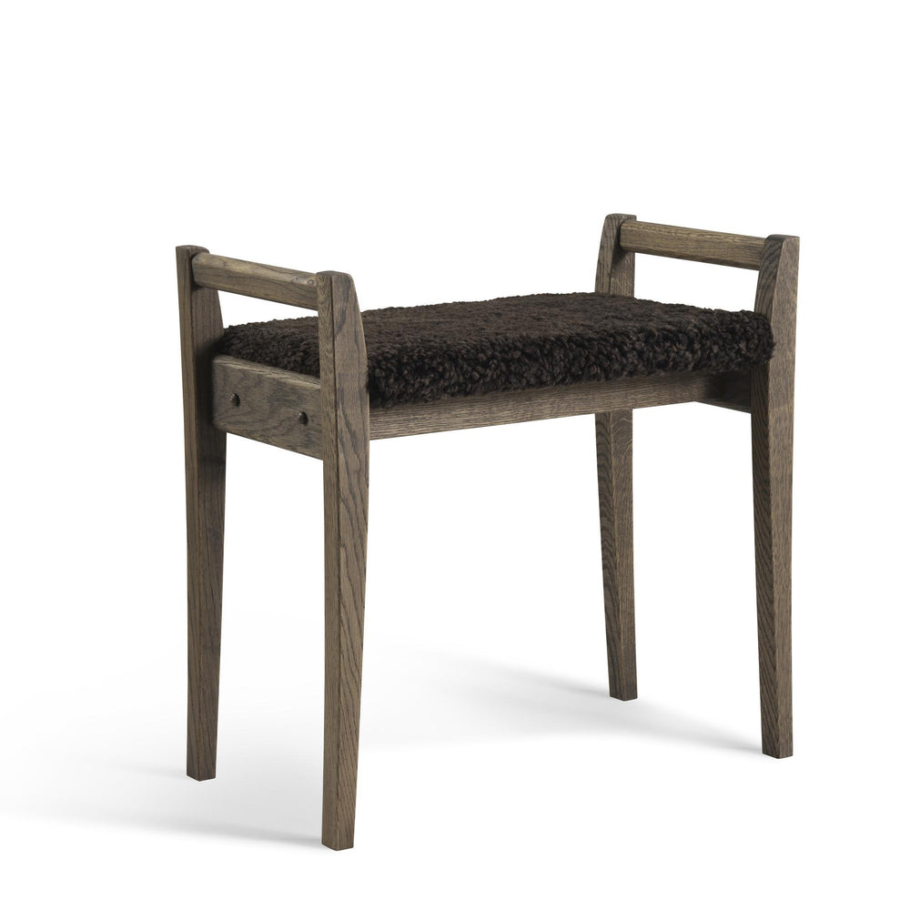 Pall i ljust trä med mörkt fårskinn, skandinavisk design med fyra ben och handtag