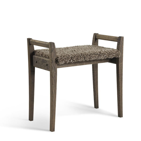 Pall i mörkbrun ek med beige fårskinnssits och armstöd i skandinavisk design