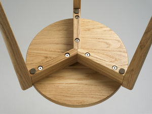 Detaljbild av tripodbordsben i ek med synliga skruvar och träkonstruktion underifrån