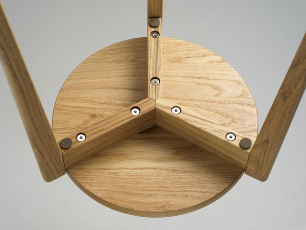 Detaljbild av tripodbordsben i ek med synliga skruvar och träkonstruktion underifrån