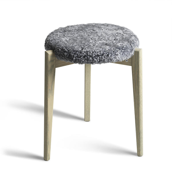 Pall med grå ullig sits och ljusa träben i modern skandinavisk design