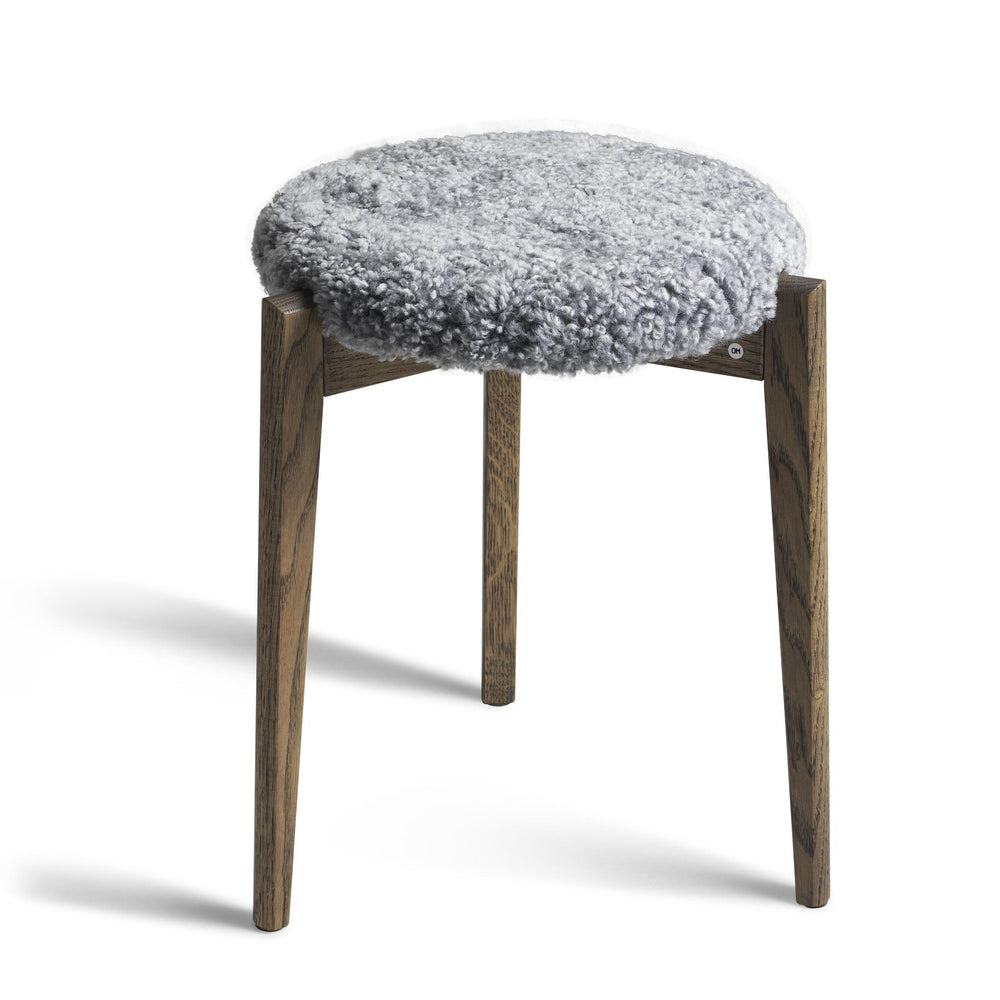 Pall med grå fårskinnsdyna och ben i ljust trä, rund design