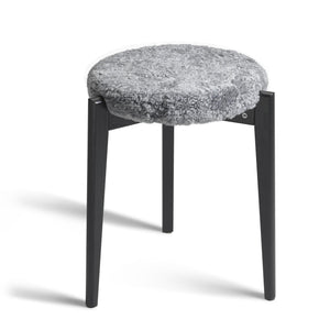 Rund pall med grå fårskinnsdyna och svarta träben