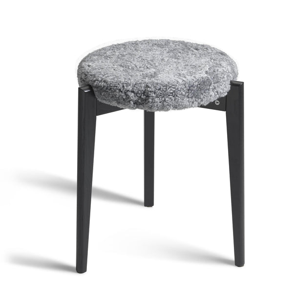 Rund pall med grå fårskinnsdyna och svarta träben