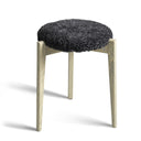 Pall med mörkgrå fårskinnsdyna och ben i ljust trä