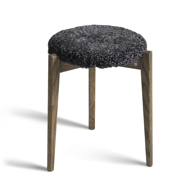 Rund pall med mörkgrå fårskinnsdyna och träben i ekfärgad finish