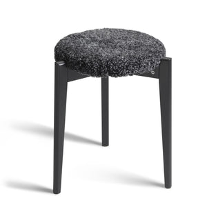 Rund pall med svart träram och grå fårskinnsdyna, modern skandinavisk design