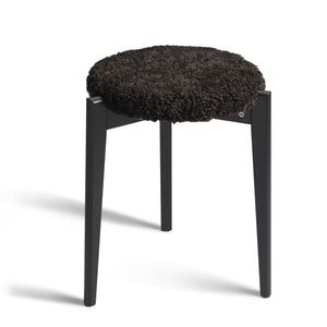 Rund pall med svart fårskinnsdyna och svarta träben