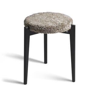 Rund pall med fluffig fårskinnsdyna i beige och svarta träben