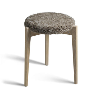 Pall med grå fårskinnsdyna och ljusa träben i ek, rund sits med naturligt ullgarn