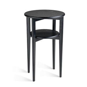 Runt svart sidobord i trä med två våningsplan och fyra ben mot vit bakgrund