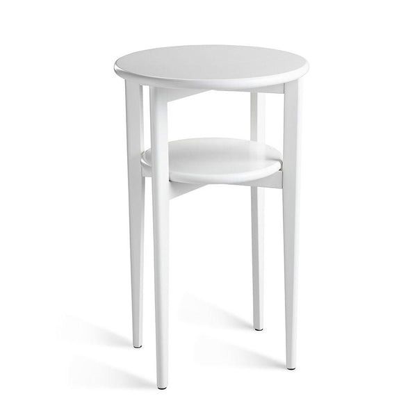 Vitt runt sidobord med två våningar och smala metallben, minimalistisk design