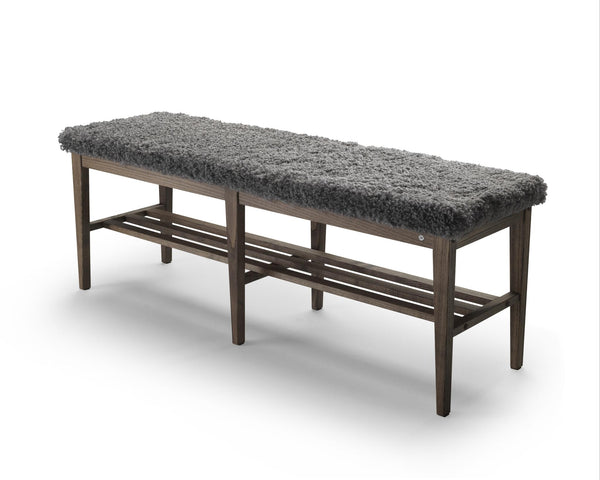 Bänk med grå fårskinnspall och mörkbrunbetsad träram med hyllplan för förvaring