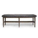 Bänk med grå fårskinnsdyna och mörkbrunt trästativ med hyllplan