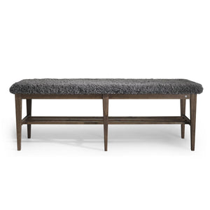 Bänk med grå fårskinnsdyna och mörkbrunt trästativ med hyllplan