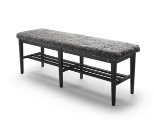 Hallbänk med grå fårskinnsdyna och svart träställning med skoförvaring