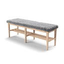 Hallbänk i ljust trä med grå luddig dyna och praktisk skoförvaring under sittdynan