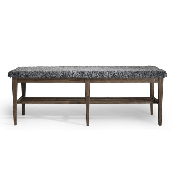 Bänk med grå pälsliknande sits och mörkbrun träram med öppen hylla