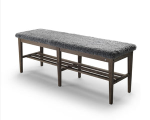 Bänk med grå pälsliknande sits och mörkt trästomme med hyllplan för skoförvaring