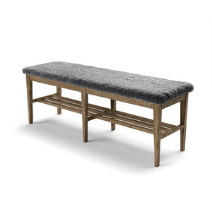 Hallbänk med grå fårskinnssits och trästomme med förvaring