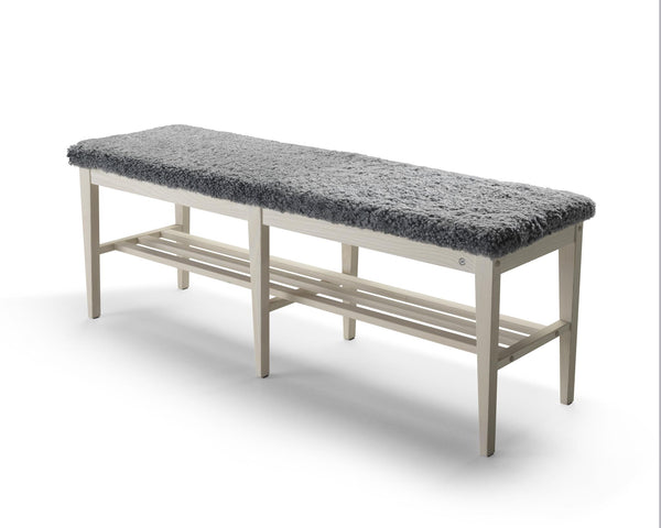 Hallbänk med grå ullig sits och vit träram med skohylla under