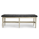 Bänk med grå fårskinnsdyna och ljust trästativ med hylla, fotad framifrån mot vit bakgrund