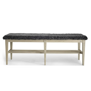 Bänk med grå fårskinnsdyna och ljust trästativ med hylla, fotad framifrån mot vit bakgrund