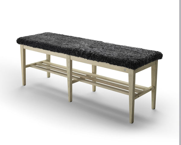 Bänk med ljust trästativ och svart fårskinnsdyna, med förvaring under sitsen