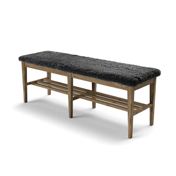Hallbänk med grå fårskinnssits och träunderrede med förvaringshylla i naturligt trä