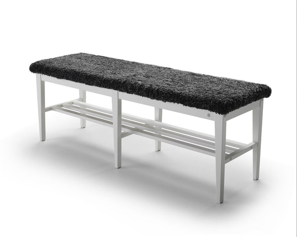 Bänk med svart fårskinnssits och vit metallram samt hylla för skor under sittdelen