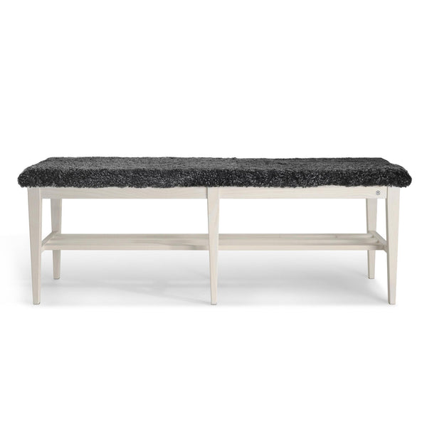 Bänk med svart fårskinnsdyna och vit träram med hylla, skandinavisk design
