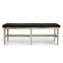 Bänk med svart fårskinnssits och ljust träunderrede med hylla