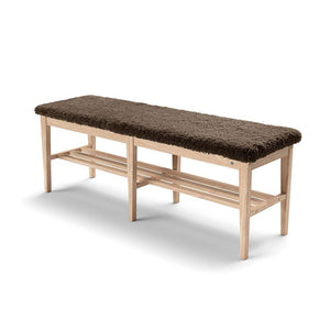 Bänk i ljust trä med mörk teddy-sits och förvaringshylla under, perfekt för hall eller sovrum