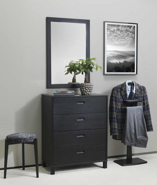 Svart byrå med fyra lådor, spegel och klädställning i modernt sovrum med grå vägg och inramad tavla