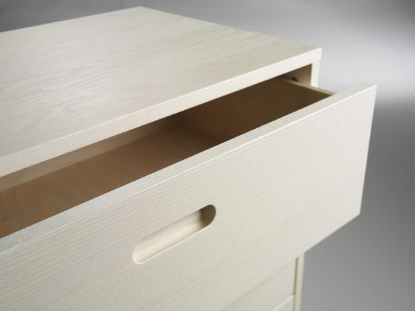 Öppen låda i ljust trä med infräst handtag på skåp eller byrå