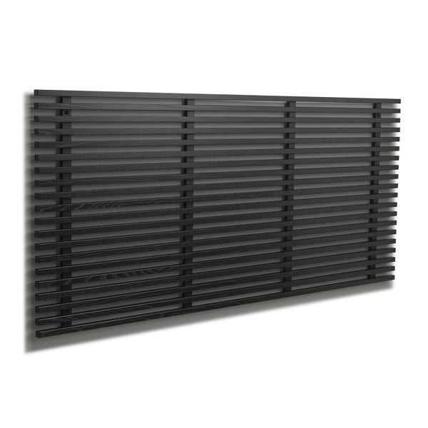 Svart horisontell designradiator med smala lameller monterad på vit vägg