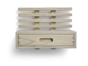 Väggmonterad sänggavel i ljust trä med fyra ribbor och praktisk låda med oval handtagsöppning