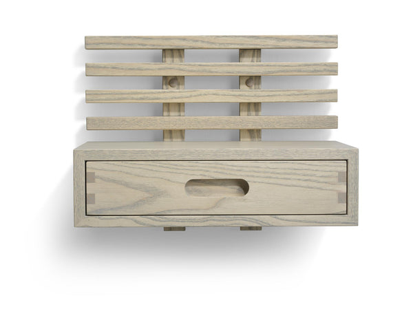Väggmonterad sänggavel i ljust trä med fyra ribbor och praktisk låda med oval handtagsöppning