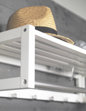 Vit metallhylla med halmhatt, närbild på hörn med skruvar och skenor i modern design