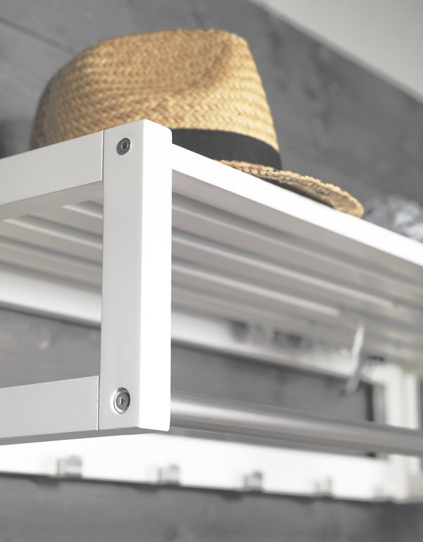 Vit metallhylla med halmhatt, närbild på hörn med skruvar och skenor i modern design