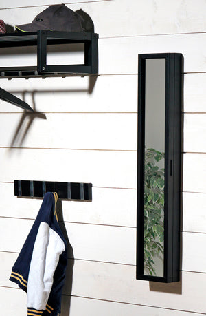Svart spegel med förvaring och krokpanel monterad på vit vägg i hall, med jacka upphängd