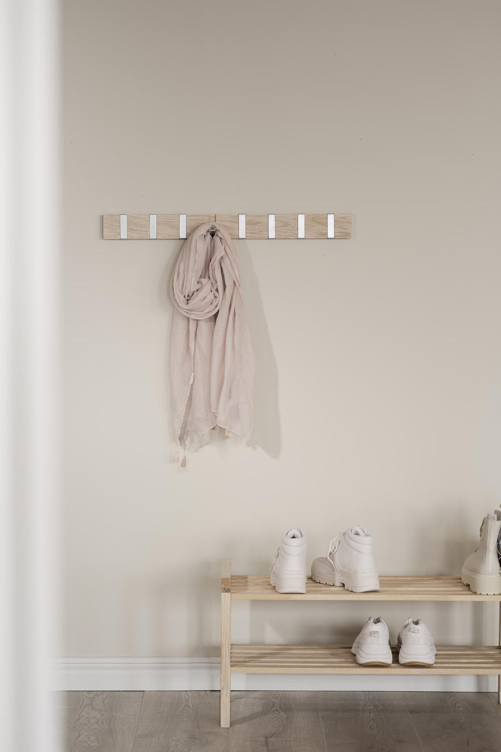 Krokpanel i ljust trä med åtta utfällbara krokar i metall för väggmontering